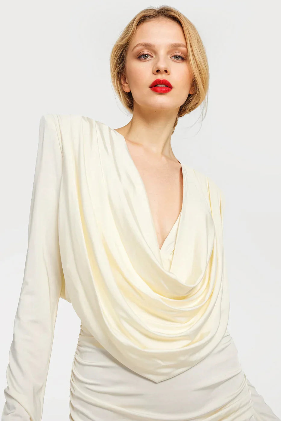 Stylish off-white mini dresses featuring a draped neckline and shoulder pads.